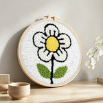 A simple little white flower punch needle artwork displayed on a table