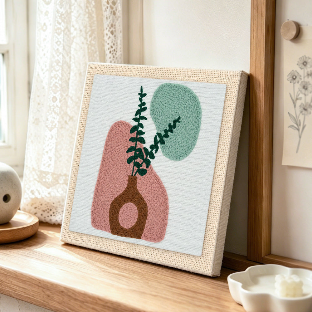 Abstract geometric vase punch needle artwork displayed on a table