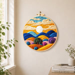 Abstract wavy clouds and colourful hills needle felt wall art displayed in a bright home interior
