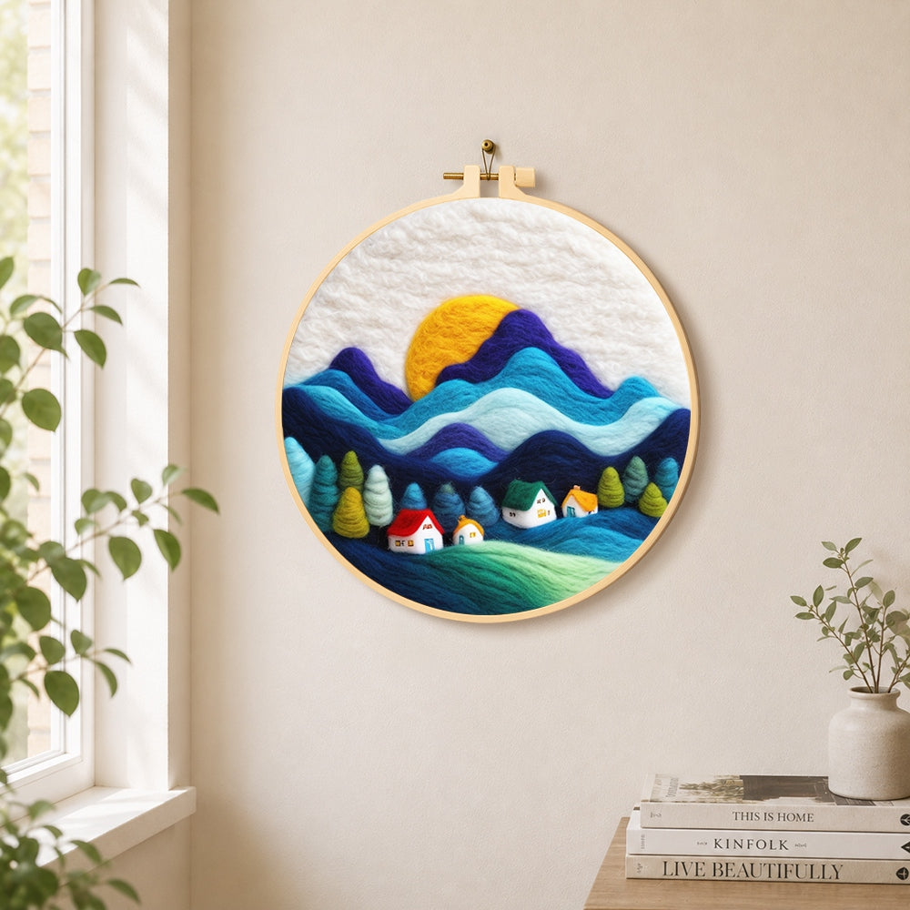Abstract wavy mountains and tiny houses needle felt wall art displayed in a bright home interior
