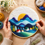 Creating the abstract wavy mountains and tiny houses wool painting by hand with a felting needle