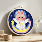 Adorable astronaut bunny on rainbow moon punch needle artwork displayed on a table