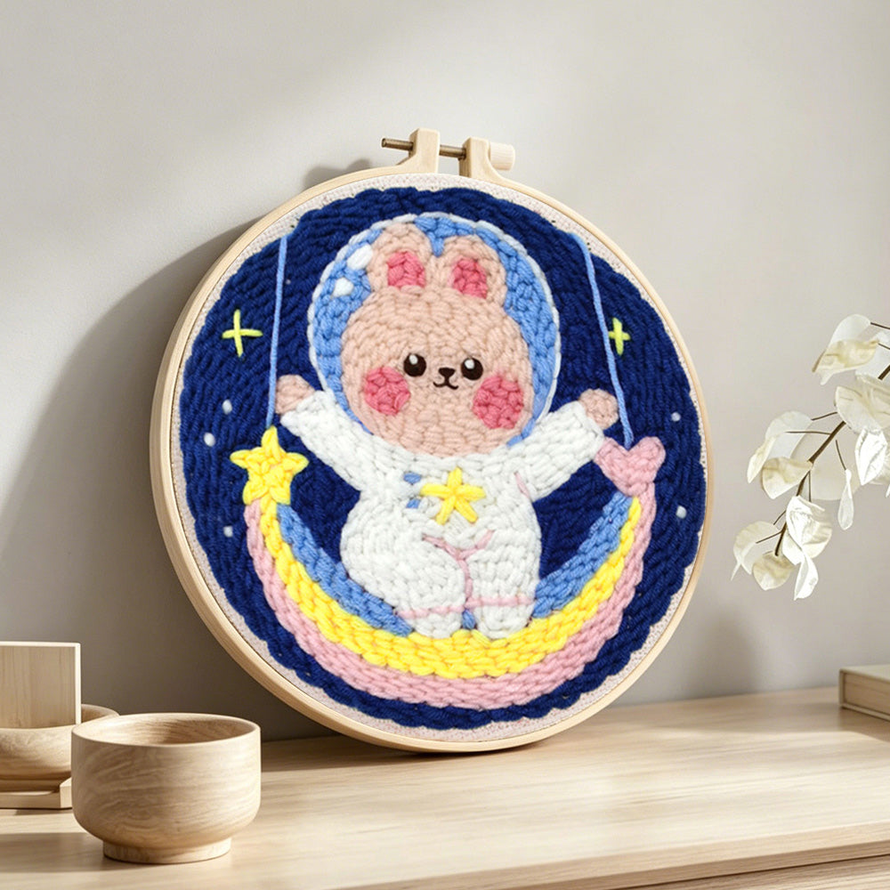 Adorable astronaut bunny on rainbow moon punch needle artwork displayed on a table