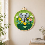 Adorable baby elephant with flowers needle felt wall art displayed in a bright home interior