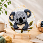 Finished adorable fluffy koala needle felting displayed on a wooden easel