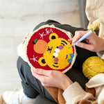 Creating handmade adorable lucky tiger with an orange punch needle artwork