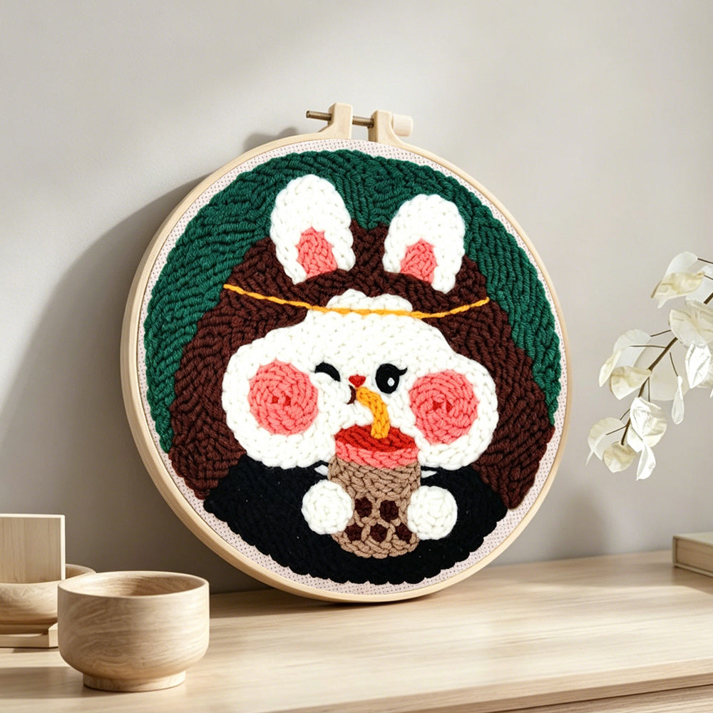 Adorable rabbit drinking bubble tea punch needle artwork displayed on a table