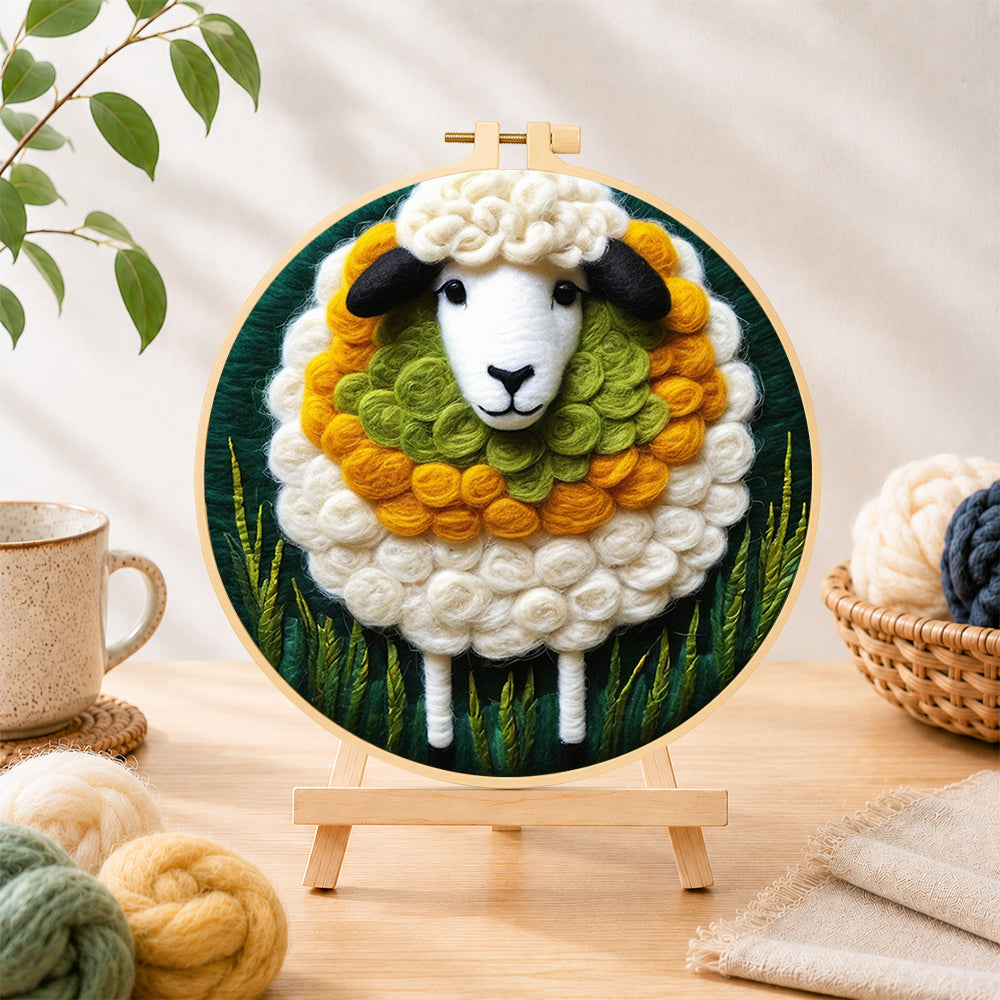 Finished adorable sheep and green grass needle felting displayed on a wooden easel