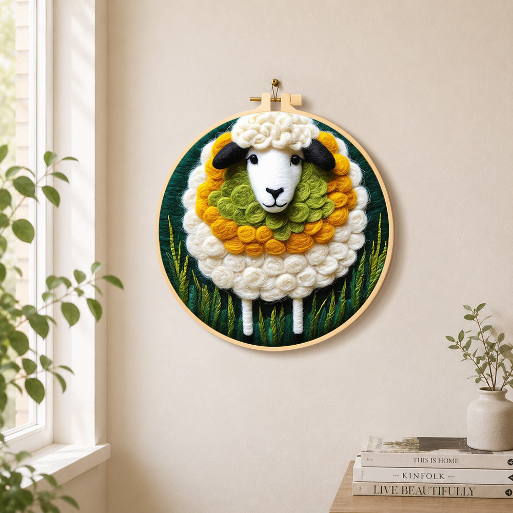Adorable sheep and green grass needle felt wall art displayed in a bright home interior