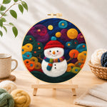 Finished adorable snowman with scarf needle felting displayed on a wooden easel