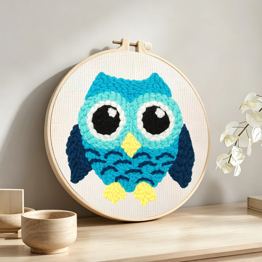Aqua owl punch needle artwork displayed on a table