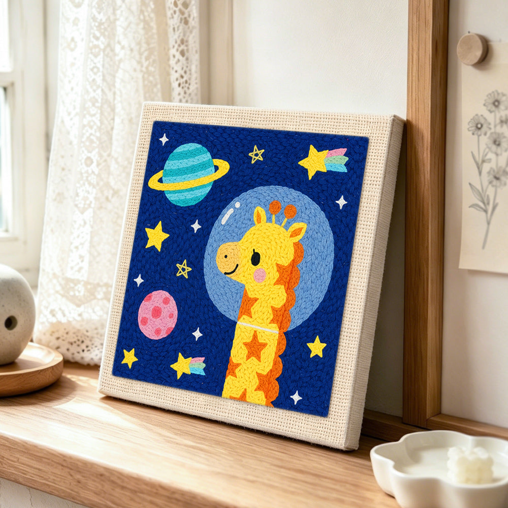 Astronaut giraffe with planets punch needle artwork displayed on a table