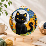 Finished autumn black cat needle felting displayed on a wooden easel