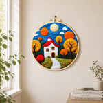 Autumn fairy tale tree and house needle felt wall art displayed in a bright home interior