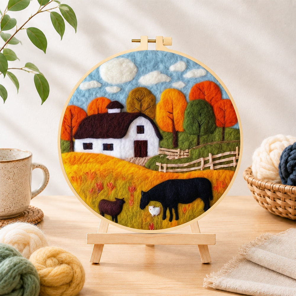 Finished autumn farm scene needle felting displayed on a wooden easel