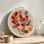 Autumn-hued leaves punch needle artwork displayed on a table