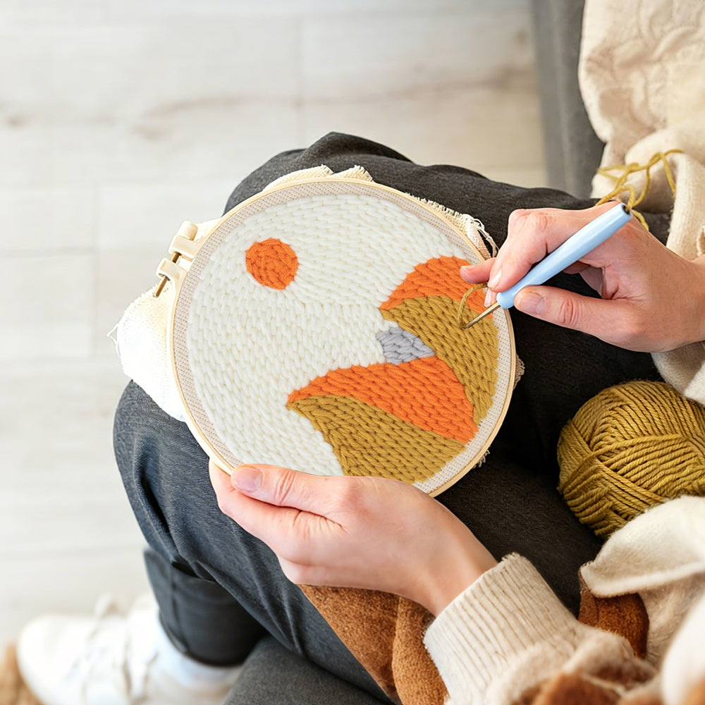 Creating handmade autumn mountain with sun punch needle artwork