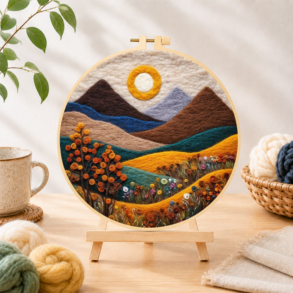Finished autumn mountains and plants needle felting displayed on a wooden easel
