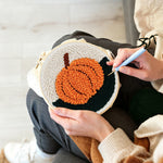 Creating handmade autumn orange pumpkin punch needle artwork