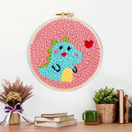 Finished baby dinosaur and little heart artwork displayed on a wall