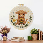 Finished baby highland cow and sunflower artwork displayed on a wall