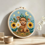 Baby highland cow and sunflowers punch needle artwork displayed on a table