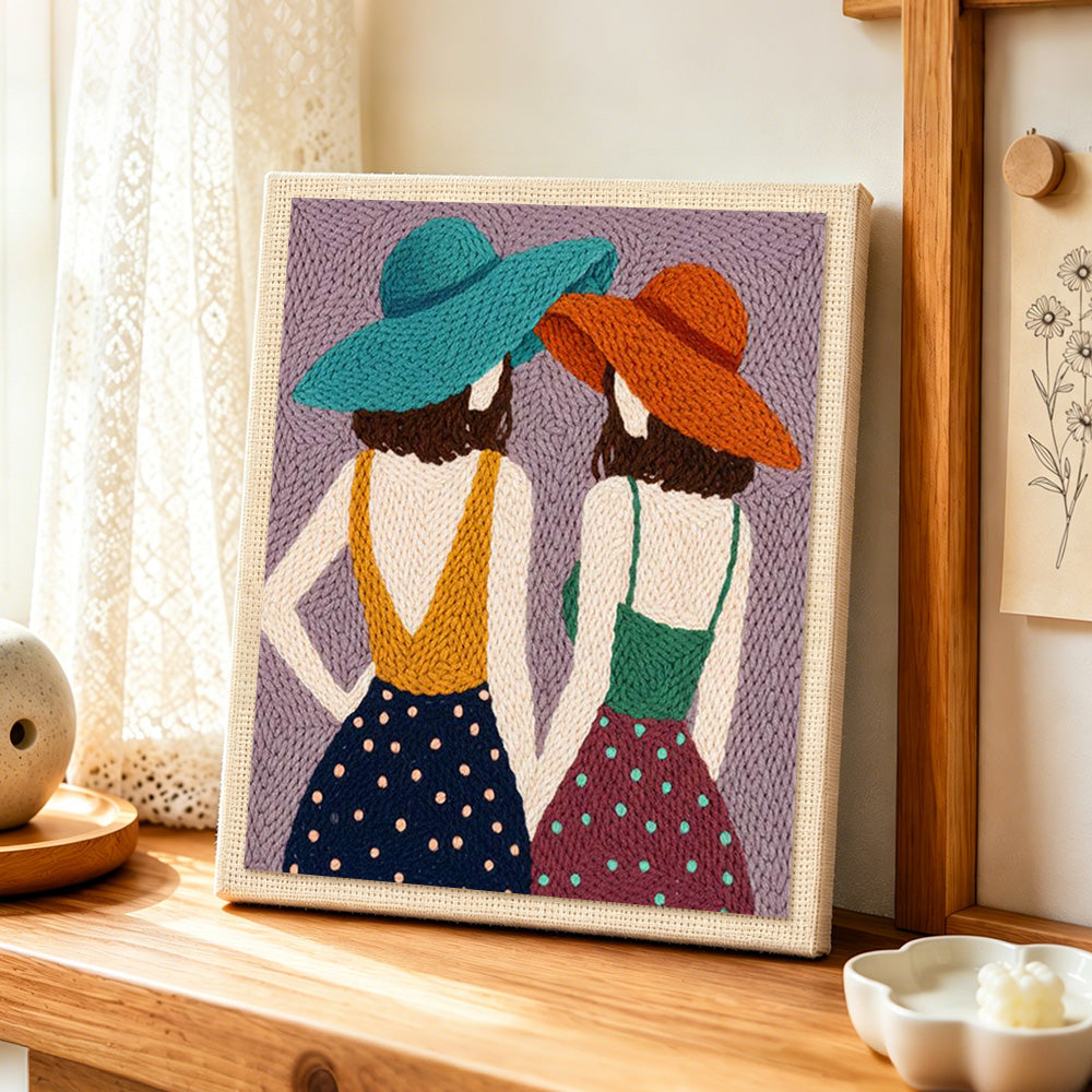 Back view women in hats punch needle artwork displayed on a table