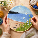 Creating the beach daisies and blue sea wool painting by hand with a felting needle
