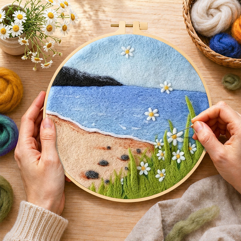 Creating the beach daisies and blue sea wool painting by hand with a felting needle