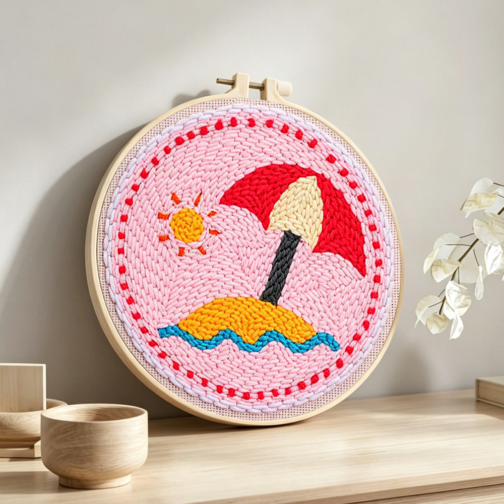 Beach umbrella on sand punch needle artwork displayed on a table