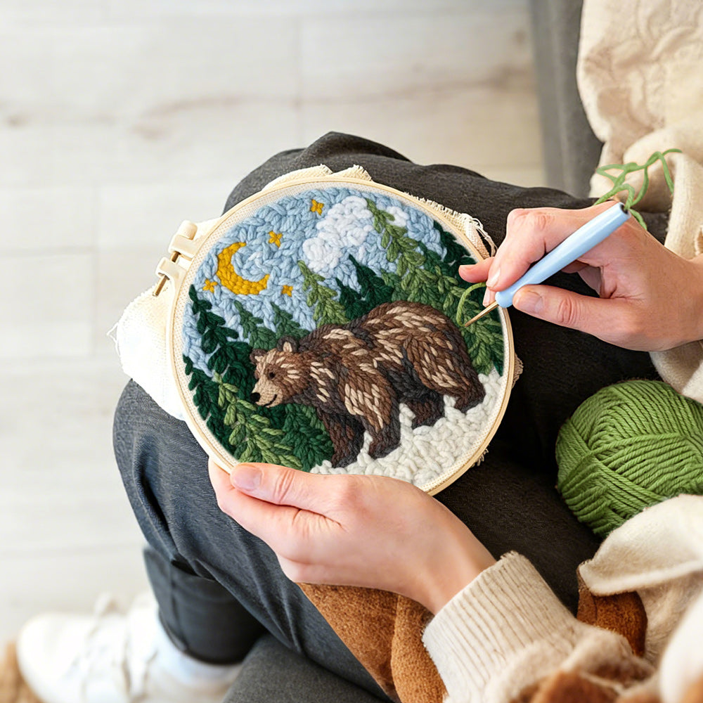Creating handmade bear in forest under moonlight punch needle artwork