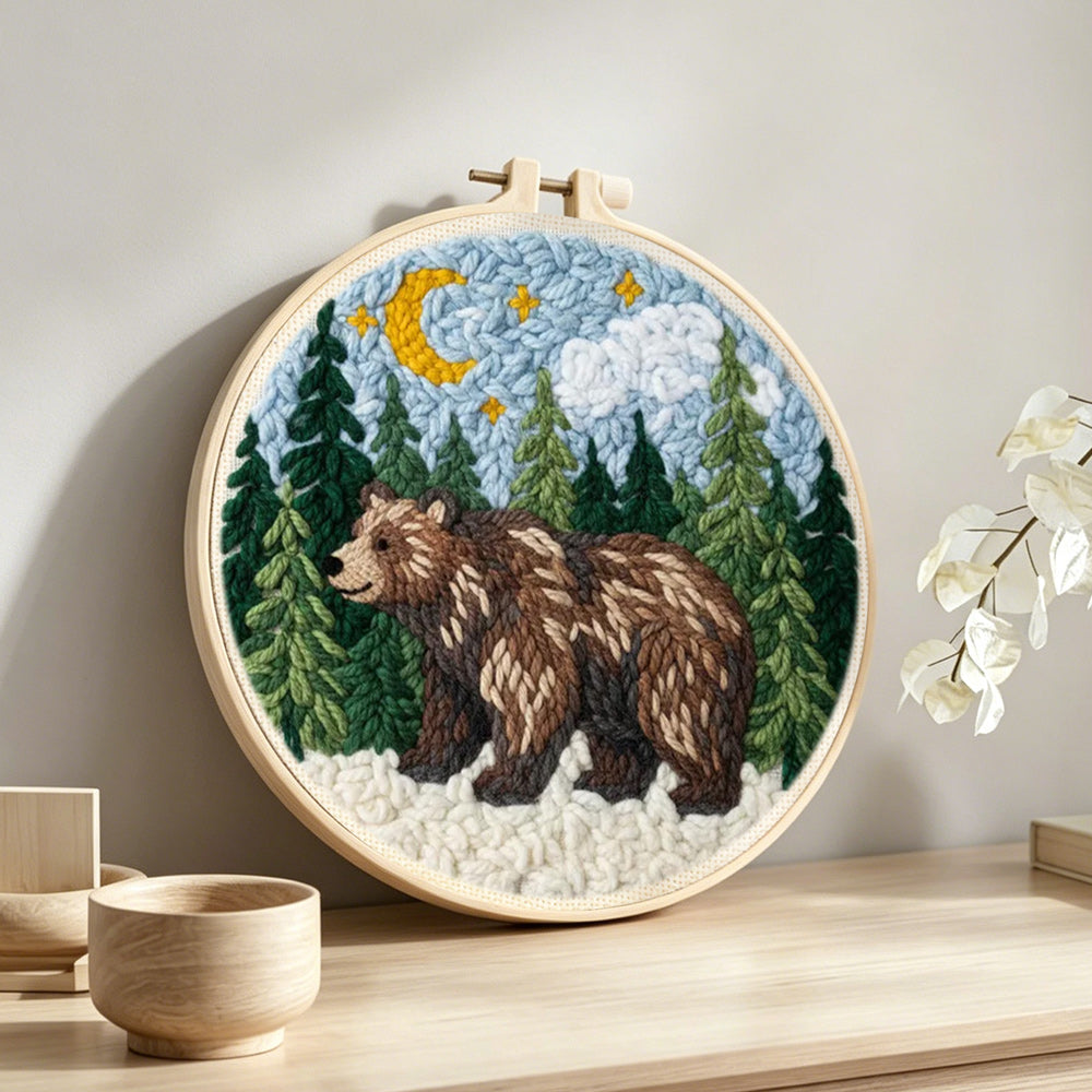 Bear in forest under moonlight punch needle artwork displayed on a table