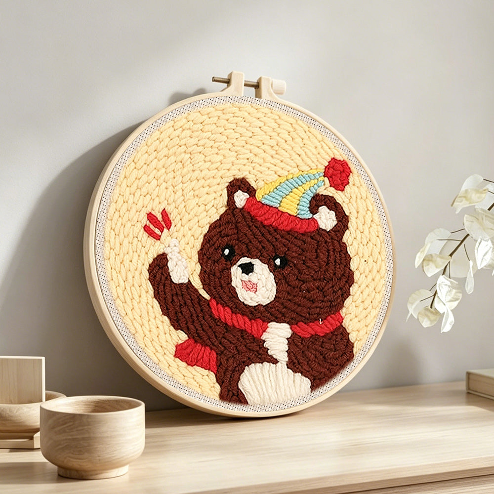 Bear with balloon and party hat punch needle artwork displayed on a table