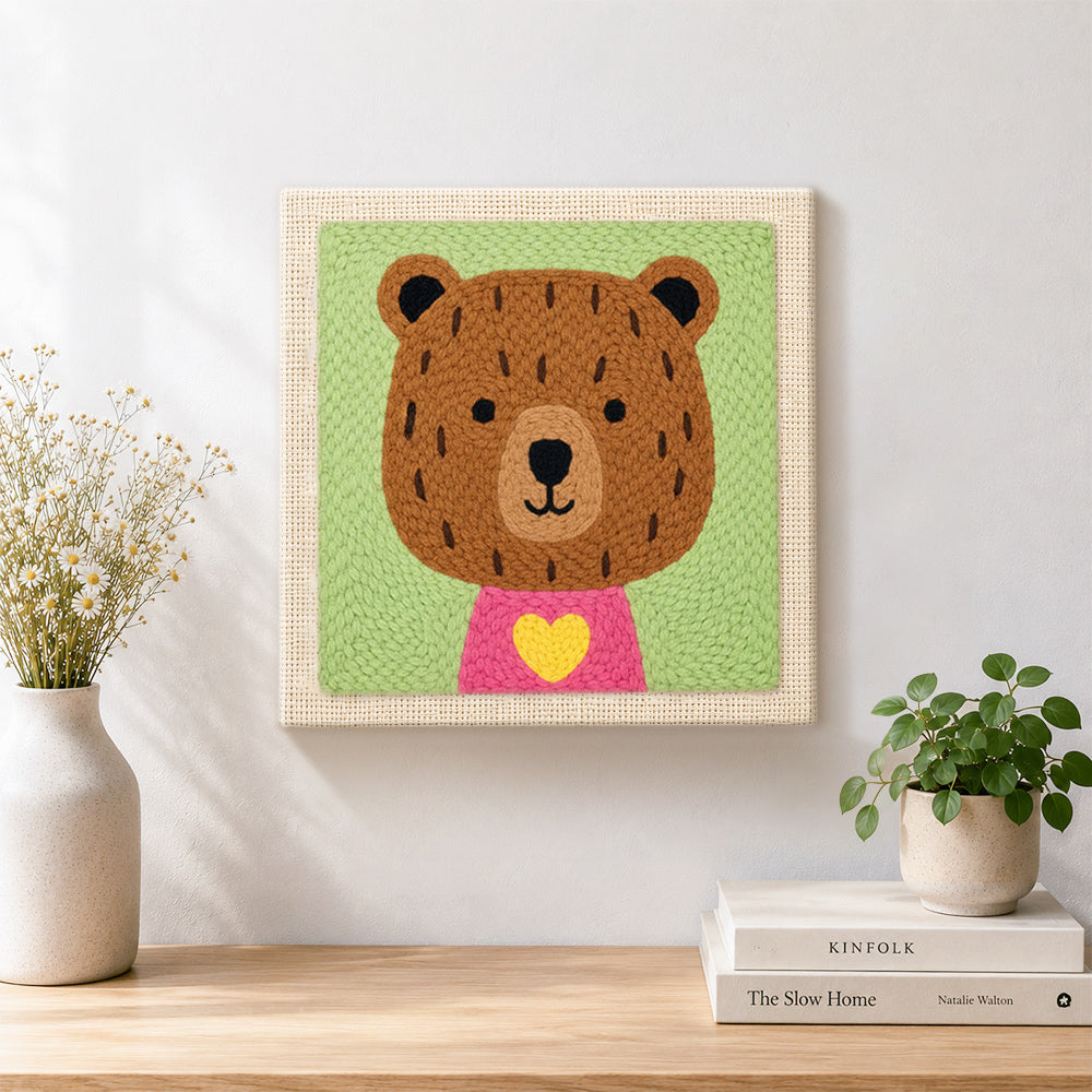 Finished bear with yellow heart artwork displayed on a wall