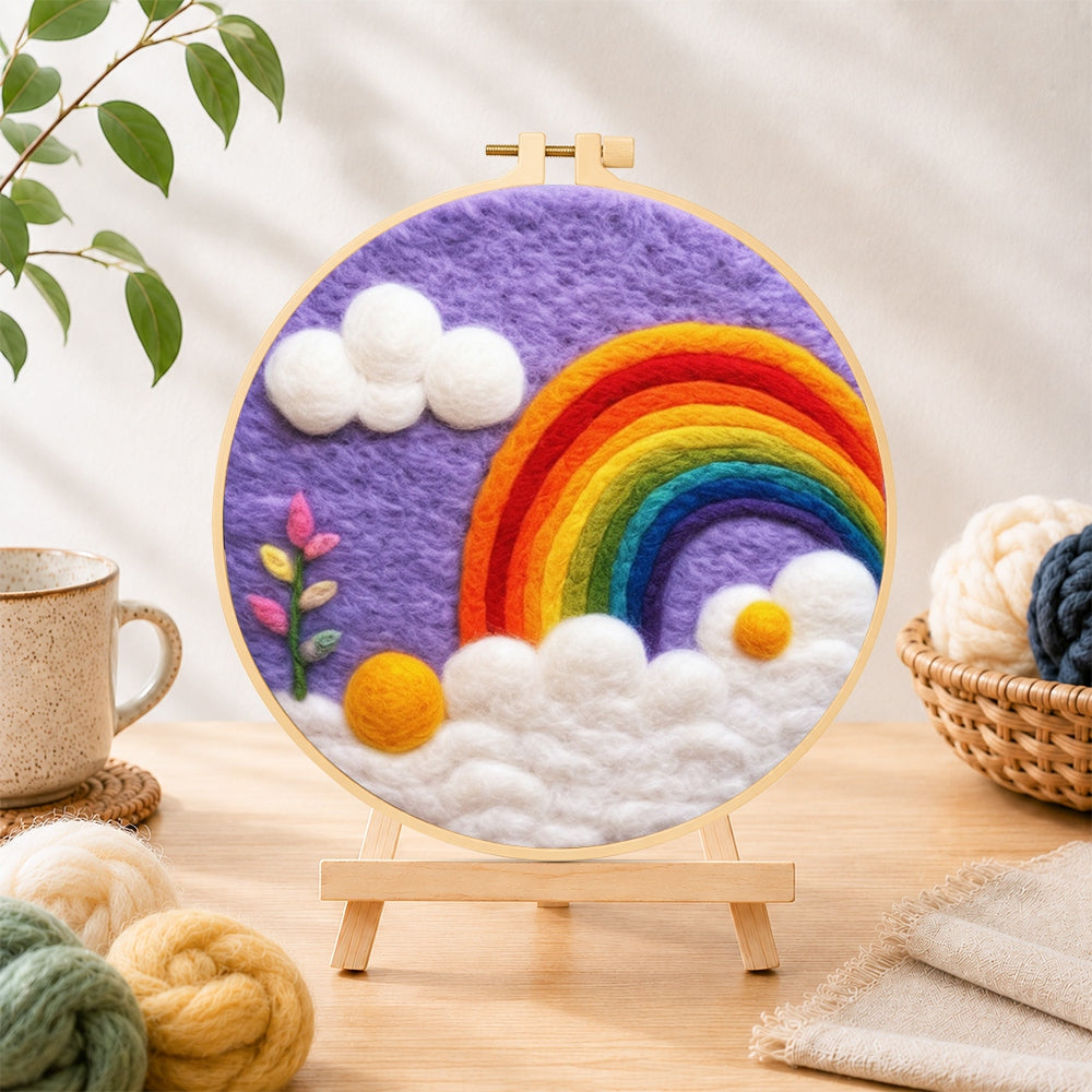 Finished beautiful rainbow and white clouds in the purple sky needle felting displayed on a wooden easel