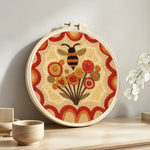 Bee and dandelions punch needle artwork displayed on a table