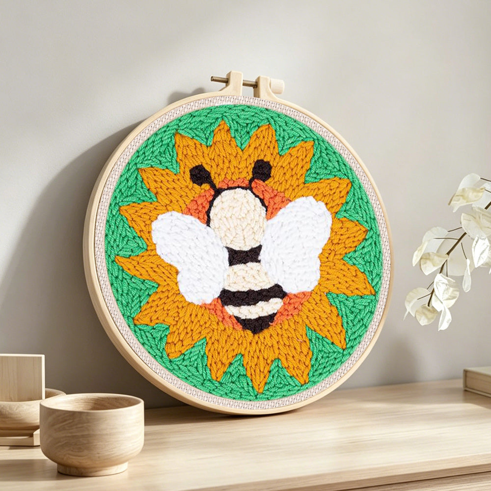 Bee and sunflower punch needle artwork displayed on a table