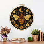 Finished bee, moon and flowers artwork displayed on a wall