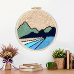 Finished beige sky, green hills and blue rivers artwork displayed on a wall