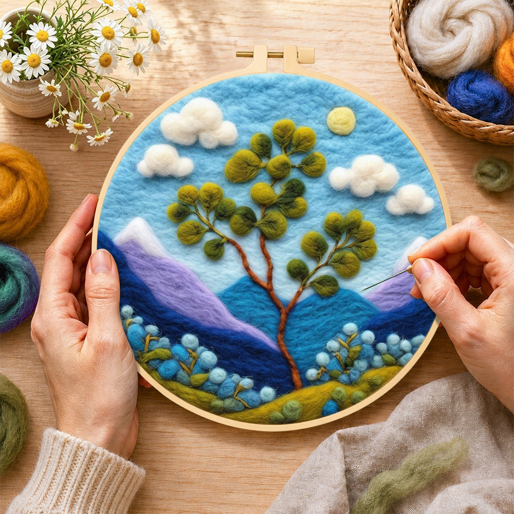 Creating the bifurcated tree and mountains wool painting by hand with a felting needle