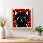 Finished big-eyed black cat face artwork displayed on a wall