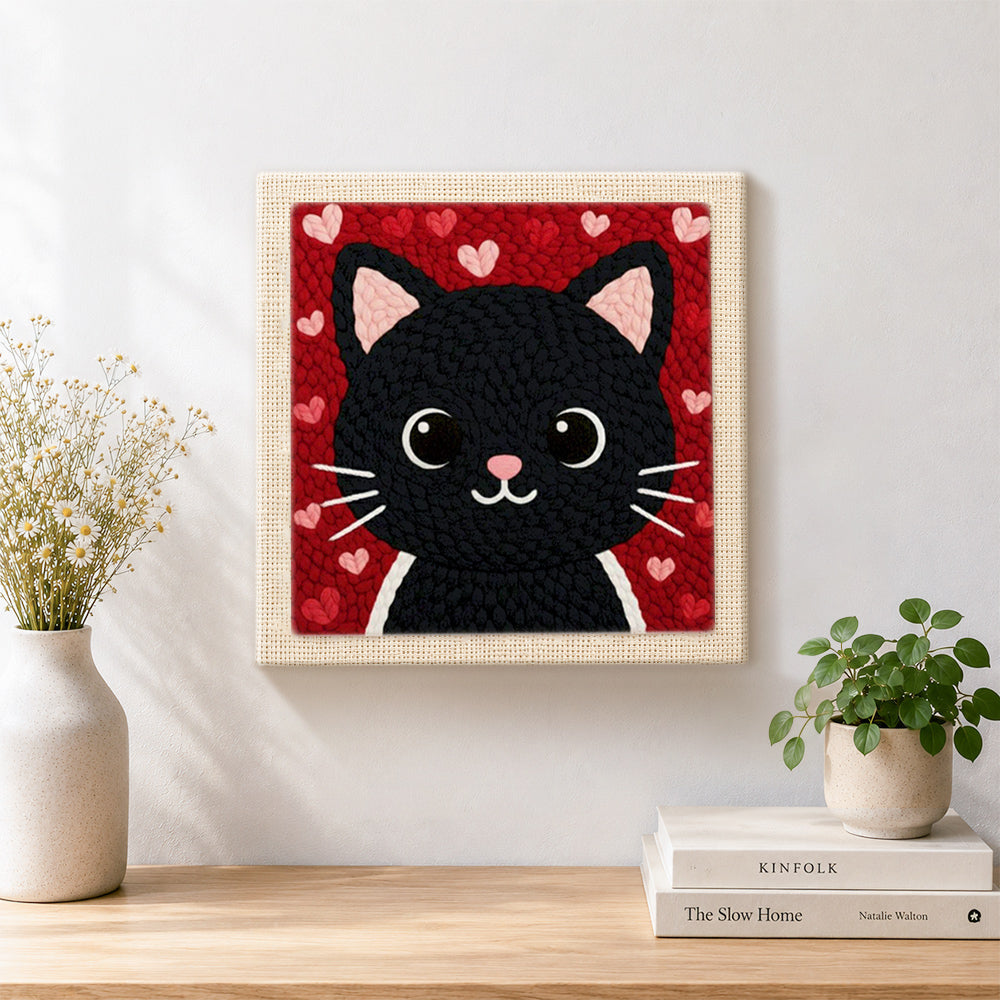 Finished big-eyed black cat face artwork displayed on a wall