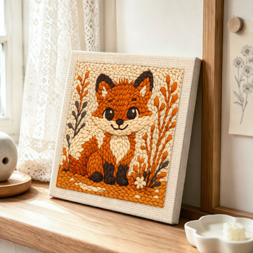 Big-eyed fox with autumn grass punch needle artwork displayed on a table
