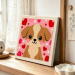 Big-eyed puppy with red hearts punch needle artwork displayed on a table