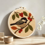 Bird and berries punch needle artwork displayed on a table