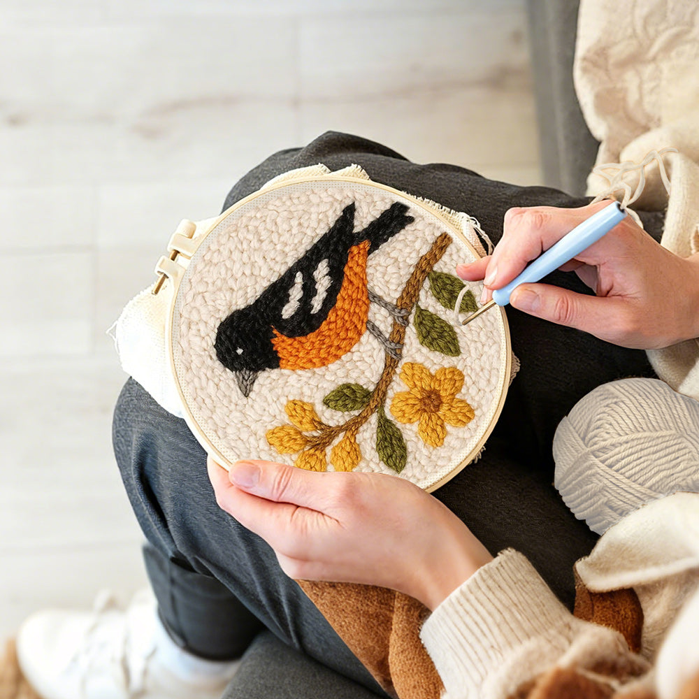 Creating handmade bird on flowering branch punch needle artwork
