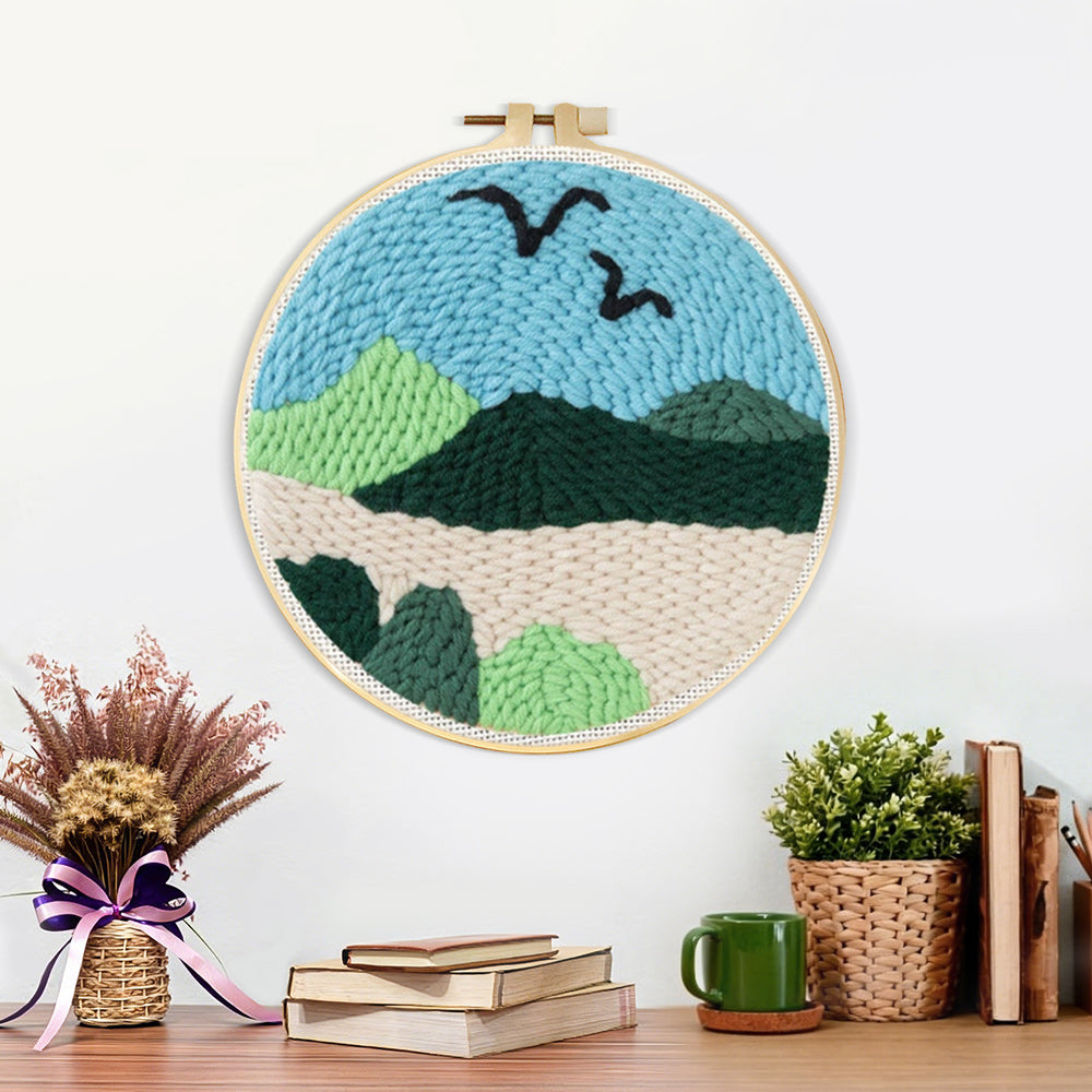 Finished birds over green mountain landscape artwork displayed on a wall