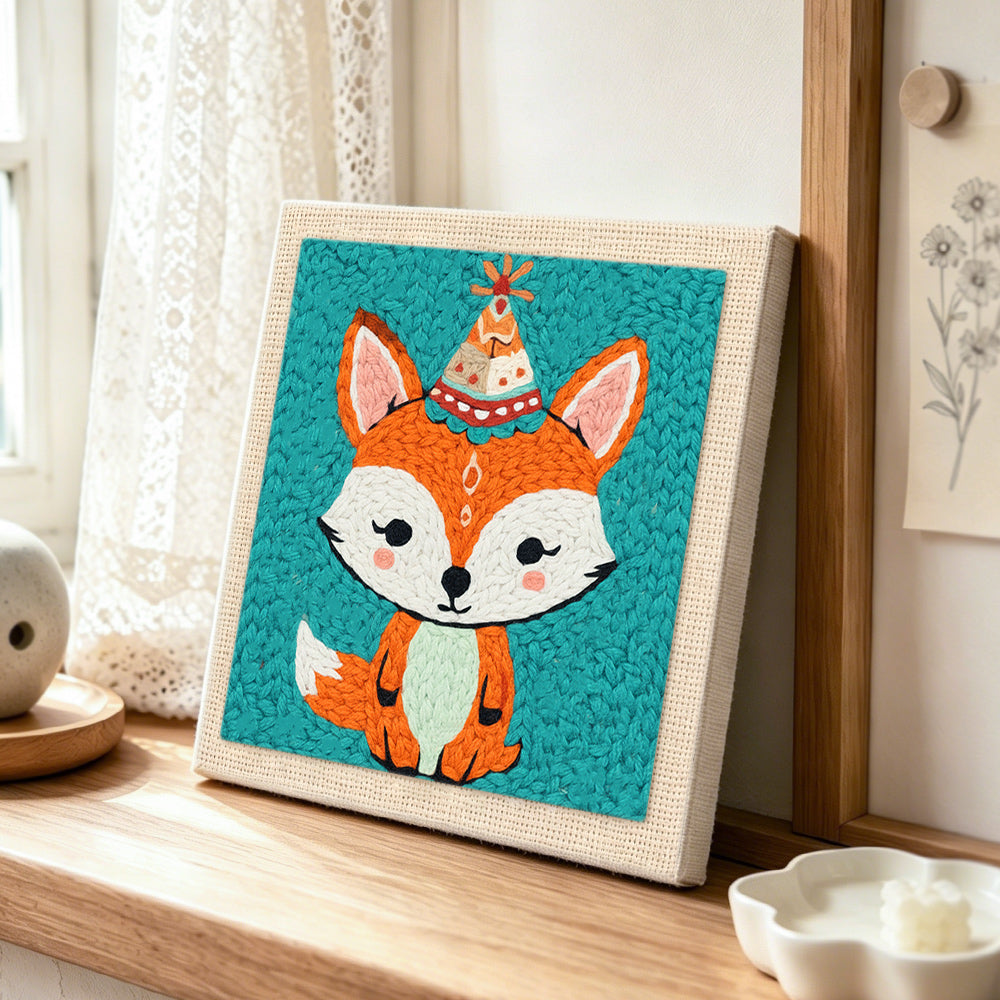 Birthday party fox with cone hat punch needle artwork displayed on a table