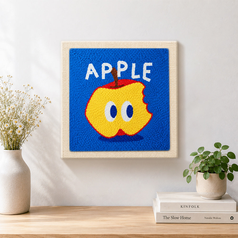Finished bitten apple with big eyes artwork displayed on a wall