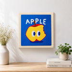 Finished bitten apple with big eyes artwork displayed on a wall